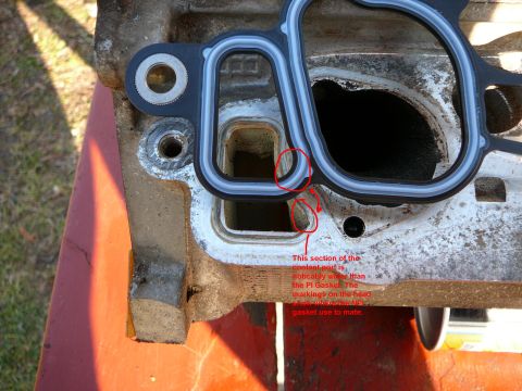 1997 Mercury Grand Marquis - Close-up of an engine part with a gasket, showing a coolant port and markings.