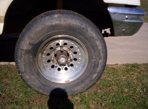 1995 Ford Bronco - A close-up view of a vehicle's front wheel and part of the chrome bumper.