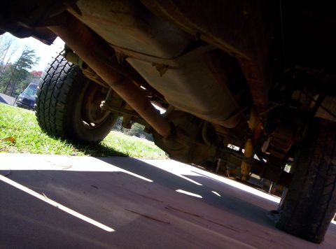 1995 Ford Bronco - This low-angle shot reveals the underside of a truck, focusing on the exhaust system and suspension parts.