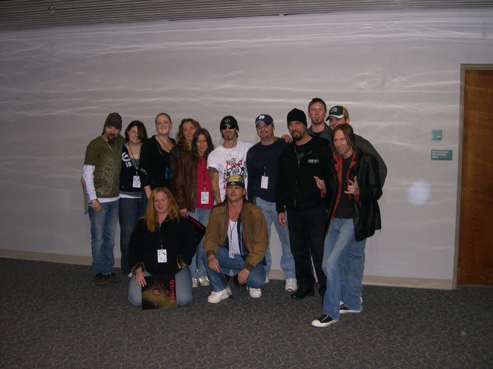 Group of people posing for a photo, one holding a record