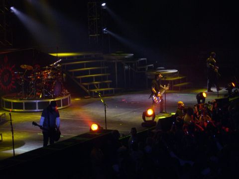 1997 Ford Probe - A band plays a concert on a stage with spotlights and a drum set visible.