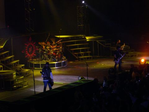 1997 Ford Probe - A band performs on stage with a drum set and lighting, while an audience watches.