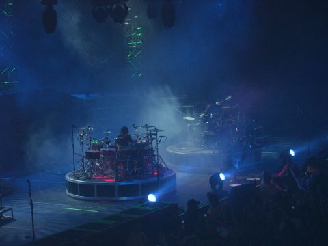 1997 Ford Probe - Two drum kits are set up on elevated platforms during a concert performance.