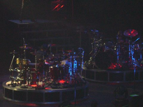 1997 Ford Probe - Two drum kits are set up on circular stages, illuminated by red and blue stage lights.