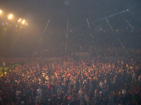 1997 Ford Probe - A large audience fills an arena, illuminated by stage lighting during a performance.