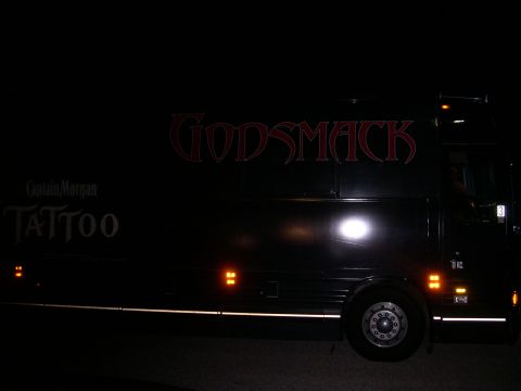 1997 Ford Probe - A black bus with the band name GODSMACK emblazoned on its side is seen at night.