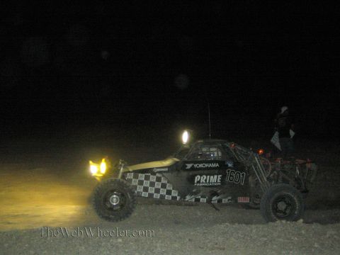 1990 Ford Bronco - black and yellow checkered off-road race buggy numbered 1601 with Yokohama and Prime Fabrication decals races at night.