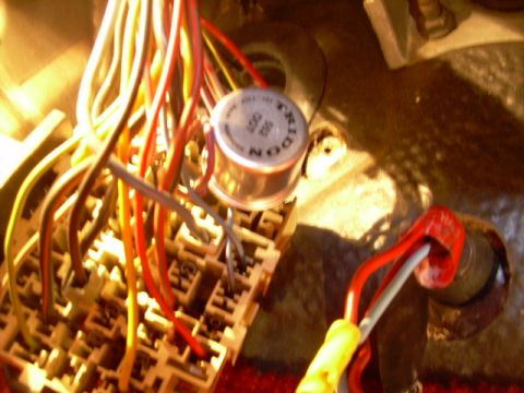 1984 Ford Bronco - A close-up view of a vehicle's electrical system, showing a fuse box and numerous colorful wires connected to a component.