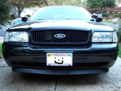 2001 Ford Crown Victoria - The front of a black Ford Crown Victoria is shown, a distinctive grille and a Virginia license plate.