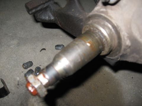 1974 Ford F-100 - Close-up of a vehicle's wheel hub and loose lug nuts on a concrete surface.