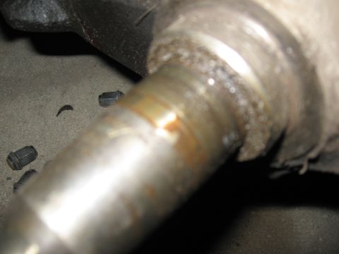 1974 Ford F-100 - A close-up view of a vehicle's axle assembly, with several lug nuts scattered on the ground.