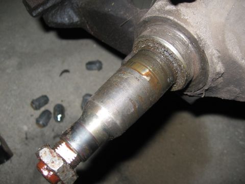 1974 Ford F-100 - A greasy vehicle suspension component is shown in detail, with loose lug nuts scattered nearby.