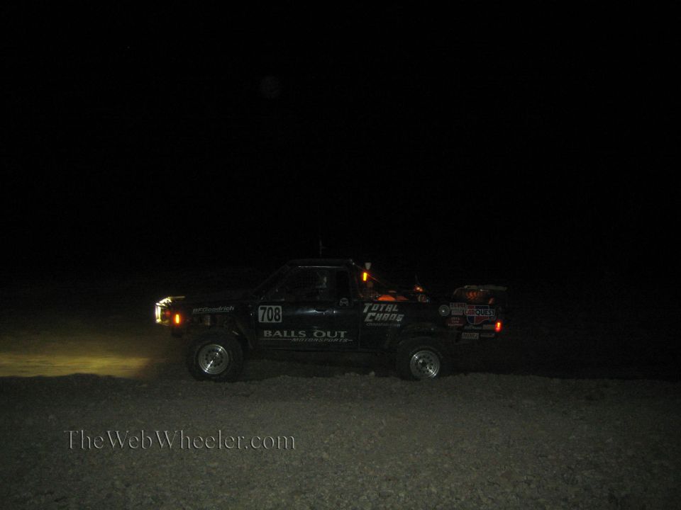 Black off-road race truck number 708 at night