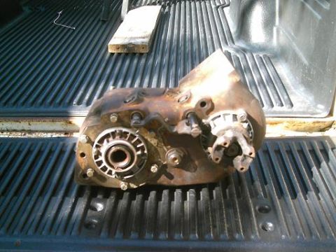 1986 Ford Bronco - A rusty transfer case is shown in the bed of a pickup truck.
