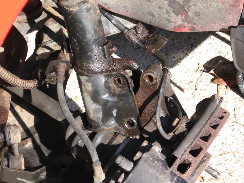 close-up of rusty suspension component with brake line