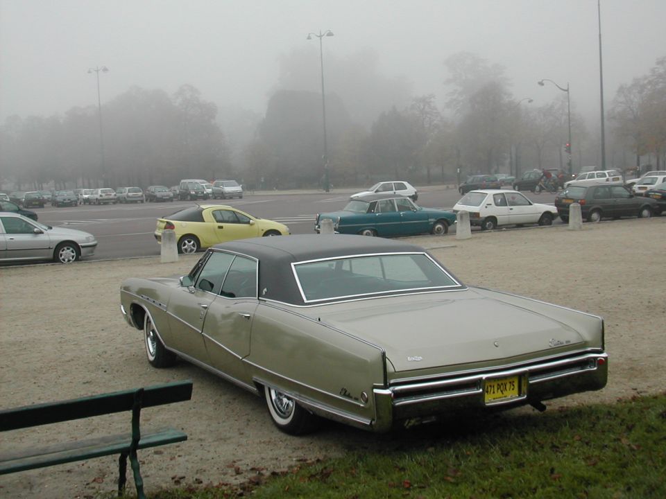 1967 Buick LeSabre parked on a gravel lot with other cars in the background