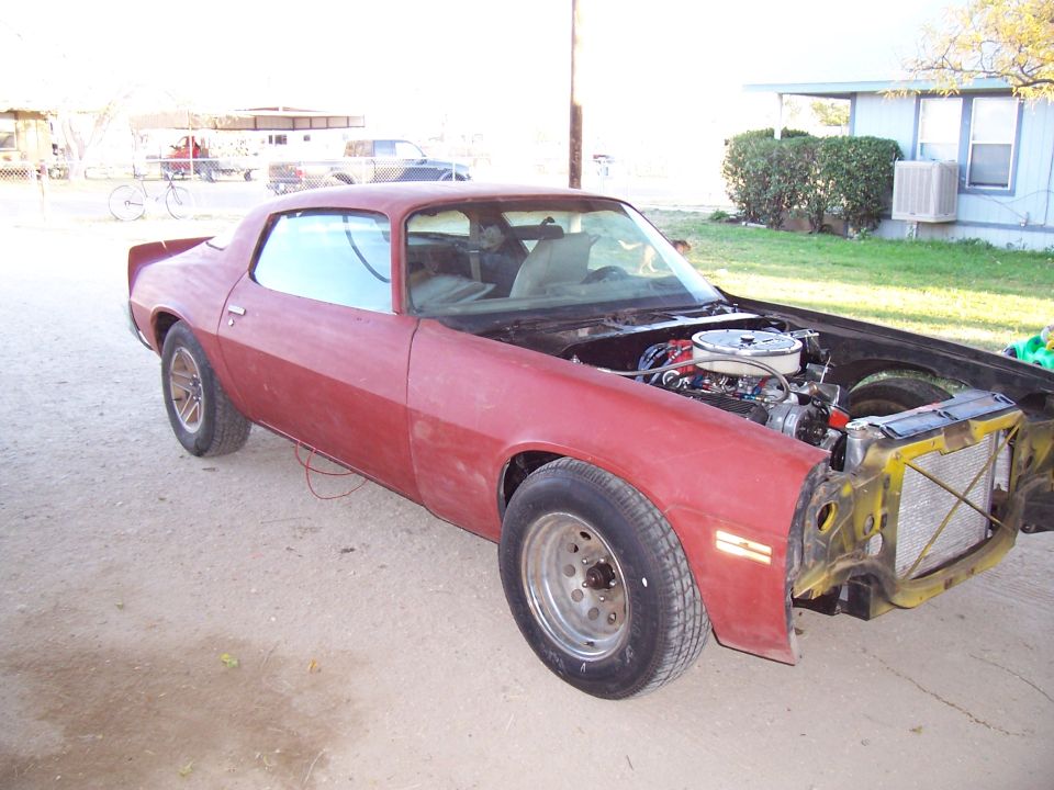 Faded red 2nd-gen Camaro coupe outdoors with front end removed, exposing V8 and core support