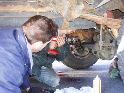1989 Ford F-350 - Mechanics perform maintenance on the rear axle assembly of a truck, using power tools.