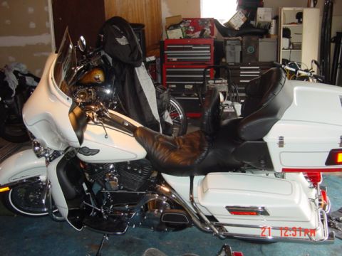 Motorcycle with white fairing, black leather seat, and saddlebags