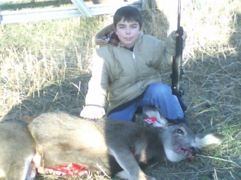 1989 Ford Bronco - A successful young hunter poses with his harvested deer in a grassy field.