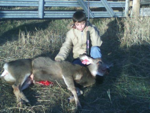 1989 Ford Bronco - A young hunter poses with a harvested deer in a field.