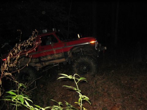 1979 Ford Bronco - This red truck appears to be a Ford F-Series from the late 1970s, possibly a 1979 model, off-roading at night.