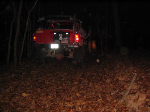 1979 Ford Bronco - Rear view of a red 1979 Ford Bronco parked on a forest trail at night.