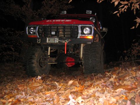 1979 Ford Bronco - This heavily modified red SUV is equipped for off-road use, large tires and a winch. Text on the hood adds a humorous touch.