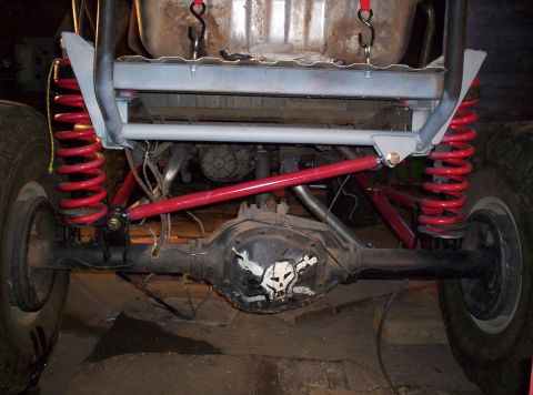 1984 Ford Bronco - The rear axle and suspension components of a heavily modified off-road vehicle are visible, a skull decal on the differential.