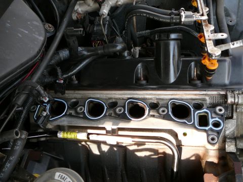 1997 Mercury Grand Marquis - Close-up view of an engine intake manifold gasket, with fuel injectors in the background.