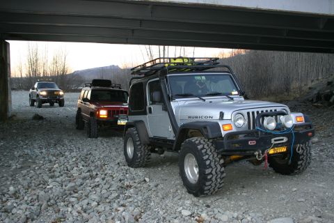 2003 Jeep TJ - Three Jeep SUVs are parked under a bridge, with the lead vehicle being a silver 2003 Jeep TJ Rubicon.