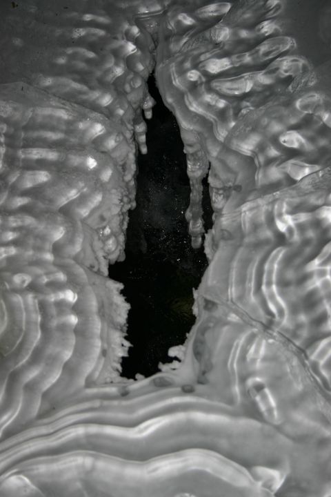 2003 Jeep TJ - Ice formations with icicles hanging over dark water, likely in a cave or crevice.