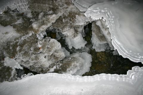 2003 Jeep TJ - A frozen stream with intricate ice formations and dark water visible beneath the ice.
