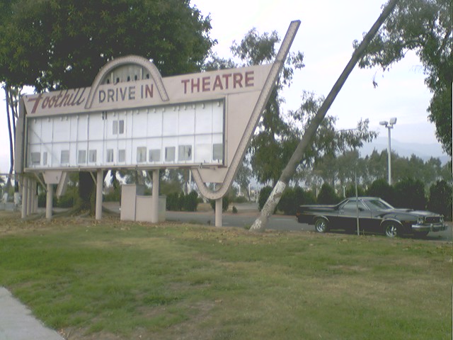 Black 1973 Ford Ranchero parked by a drive-in theater sign