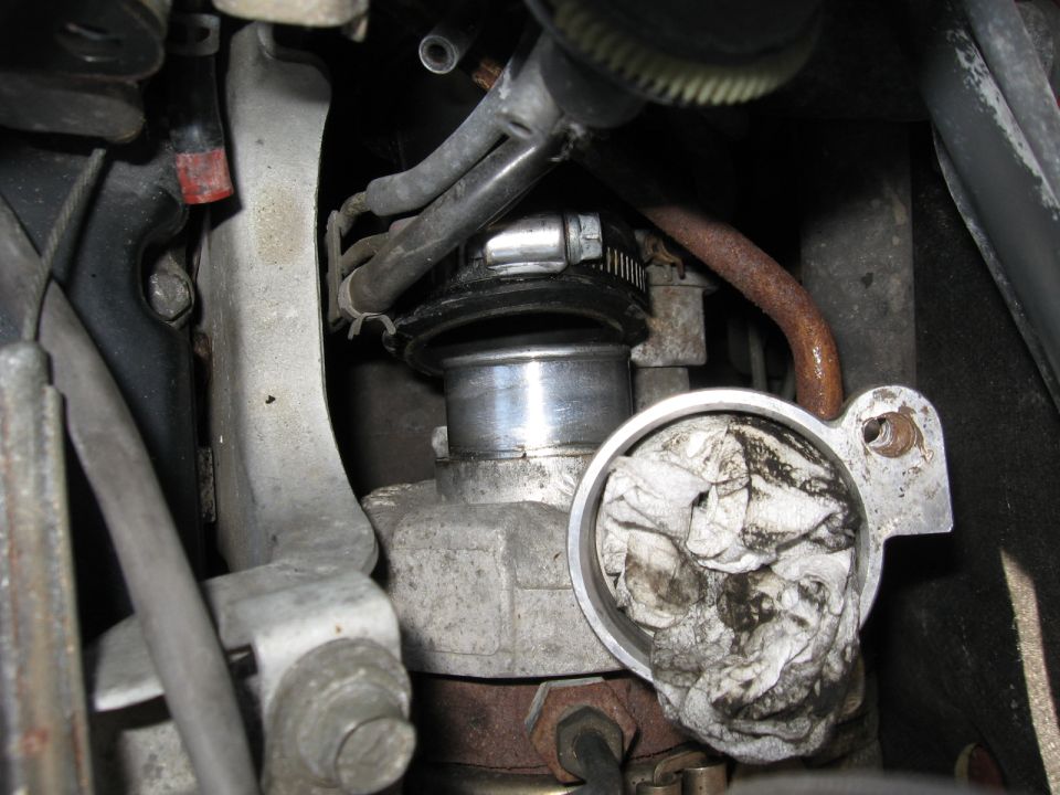 close-up of engine component with a rag stuffed inside