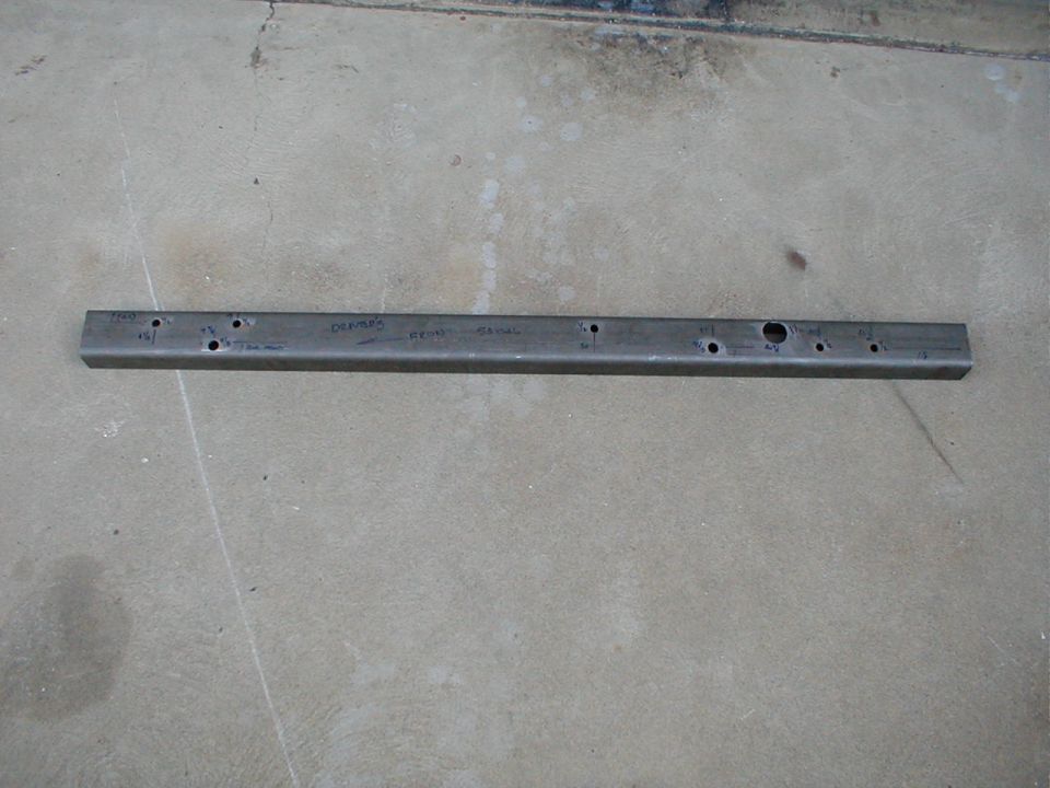Metal bracket with drilled holes and handwritten text 'CHAMPION' and 'REAR SPRING'