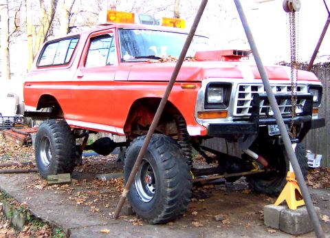 1978 Ford Bronco - This lifted 1978 Ford Bronco features a prominent hood scoop and is supported by jacks.