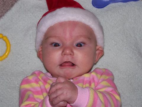 1995 Ford Bronco - Baby in a Santa hat with a surprised expression, lying on a textured surface.