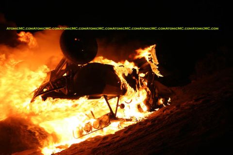 1968 Ford Mustang - A vehicle is consumed by fire, with flames and smoke dominating the dark scene.