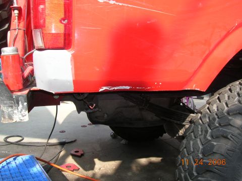 1985 Ford Bronco - Close-up of a red SUV's rear section, revealing suspension components and a tire, with a date stamp of 11.24.2006.