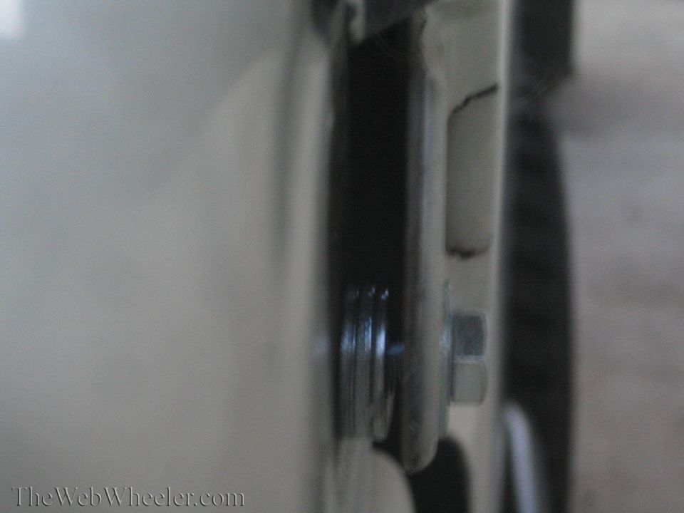 Close-up of a bolt and washer on a vehicle's frame