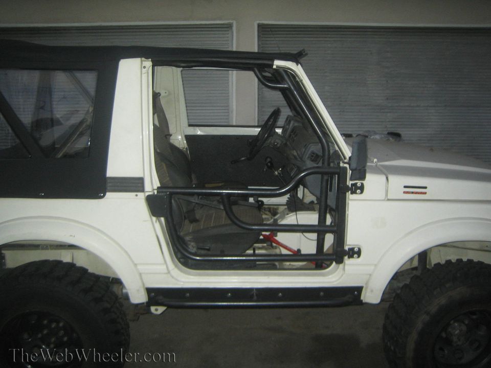 1987 Suzuki Samurai side view showing interior, roll cage, and tube doors