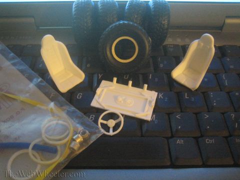 1968 Ford Mustang - Various unassembled model car components are laid out on a computer keyboard.