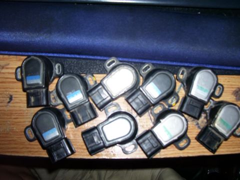 1993 Mazda MX-6 - A collection of throttle position sensors, likely for automotive repair or replacement, are displayed on a table.