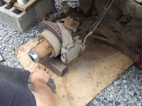 1995 Ford Bronco - Close-up of a vehicle's front wheel hub and brake system, partially disassembled.