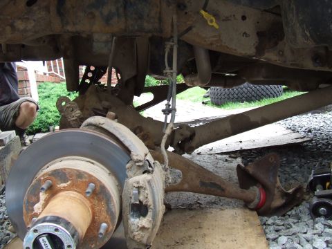1995 Ford Bronco - Undercarriage view of a 1995 Ford Bronco, highlighting the front suspension and brake components, likely modified with a lift kit.