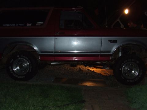 1995 Ford Bronco - This lifted 1995 Ford Bronco features a two-tone red and silver paint scheme and appears to have a suspension modification.