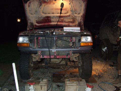 1995 Ford Bronco - Front view of a 1995 Ford Bronco with its hood up and grille removed for maintenance.