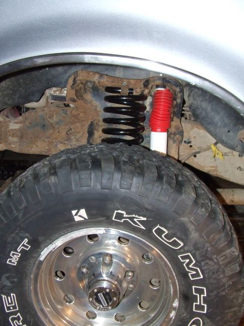 1995 Ford Bronco - This image shows a close-up of a vehicle's suspension system and a large tire, not a specific model year.