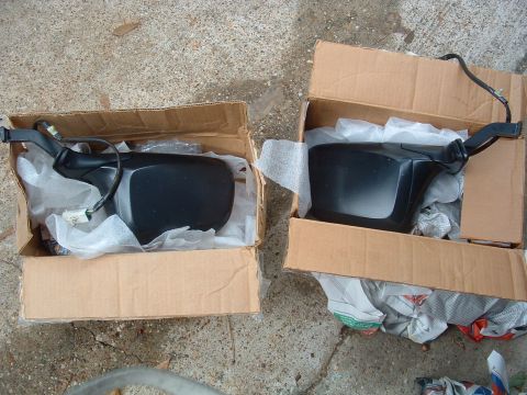 1993 Ford Bronco - Two black side mirrors are shown in their original packaging, ready for installation.